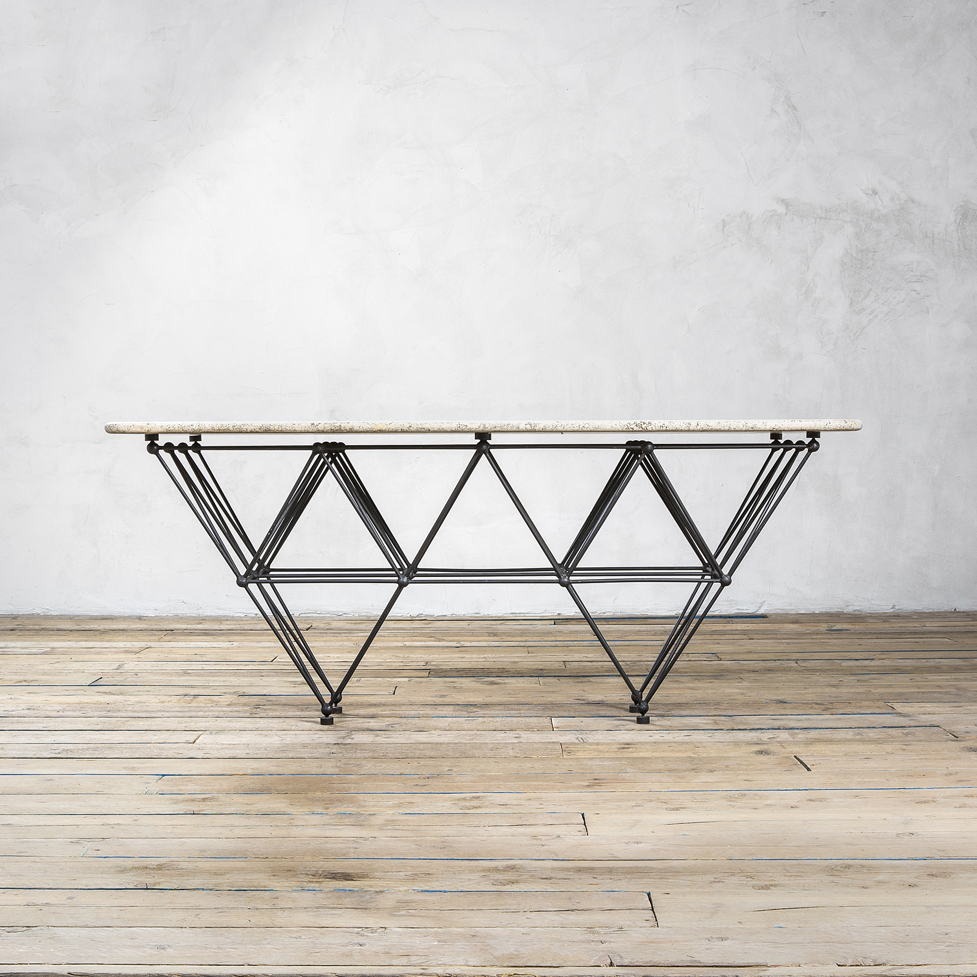 Tavolo di Giovanni Ferrabini in metallo reticolare e piano in travertino